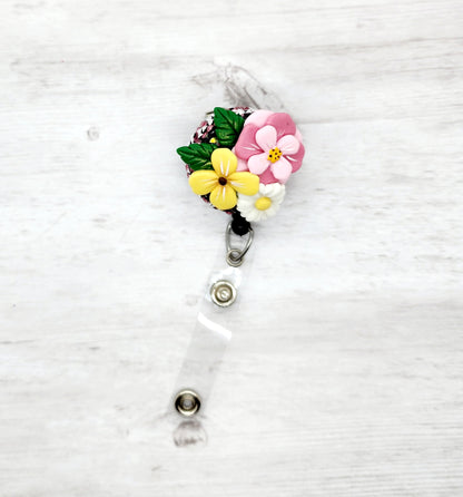 Badge reel with a clay flower attached to it