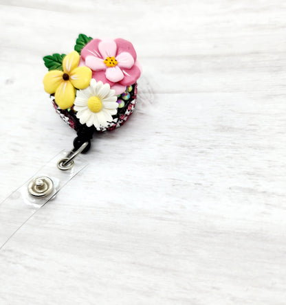 Badge Reel with clay flowers attached to it 